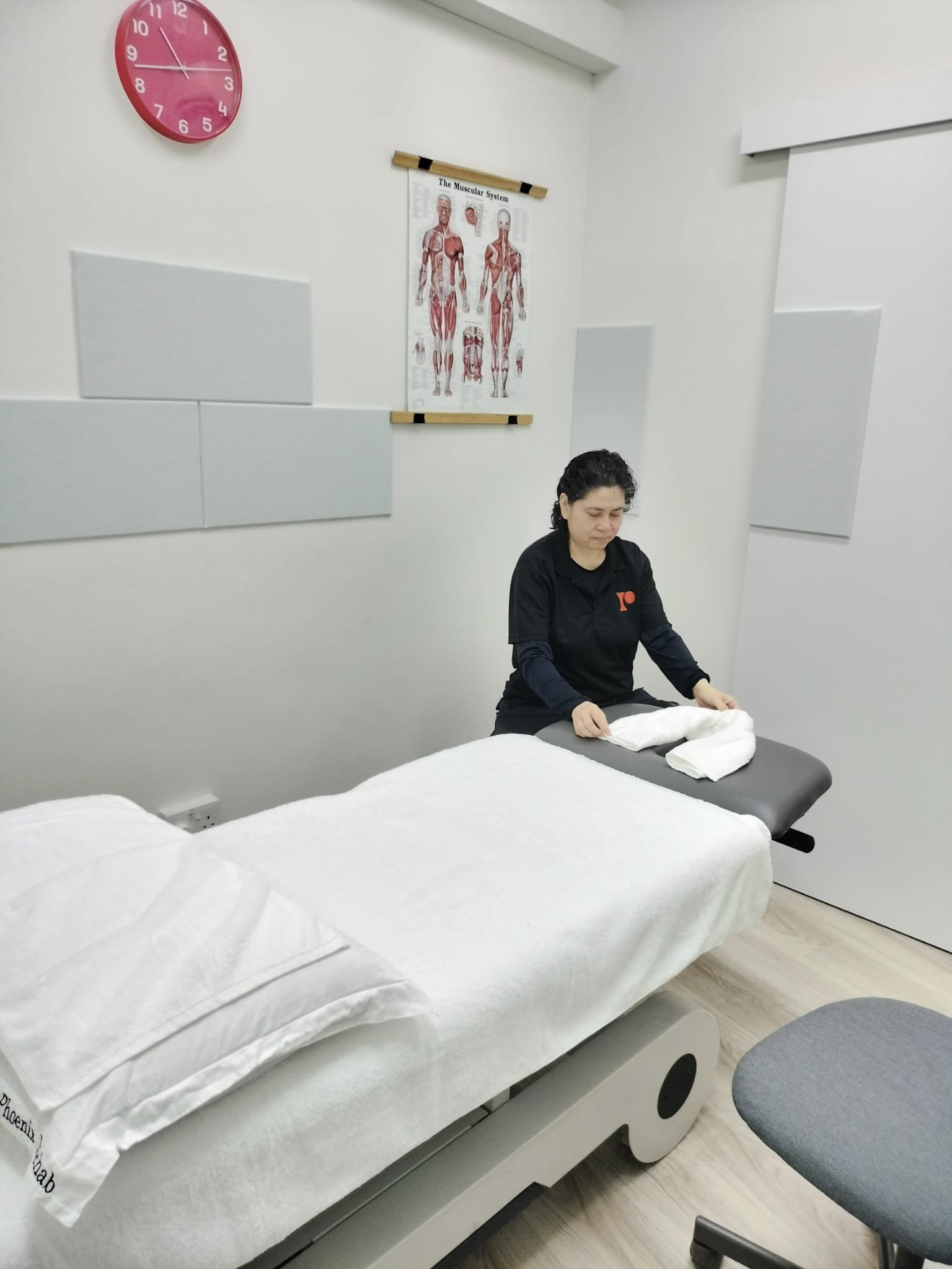 Norhayati Ahmad, sports and deep tissue massage therapist, preparing the treatment table at Phoenix Rehab Serangoon
