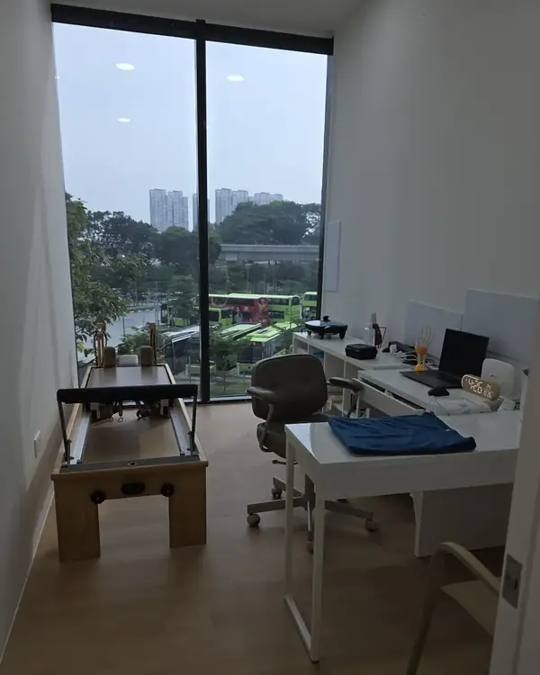 Consult room at Phoenix Rehab Jurong East, with a Pilates reformer and therapist desk beside a floor-to-ceiling window